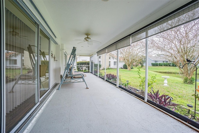 unfurnished sunroom featuring ceiling fan