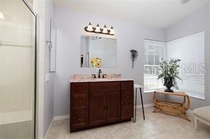 bathroom featuring tile patterned flooring, vanity, and an enclosed shower