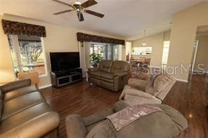 living room with dark hardwood / wood-style floors, ceiling fan, and lofted ceiling