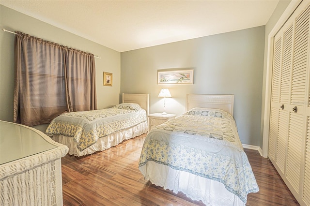 bedroom with a closet and dark wood-type flooring