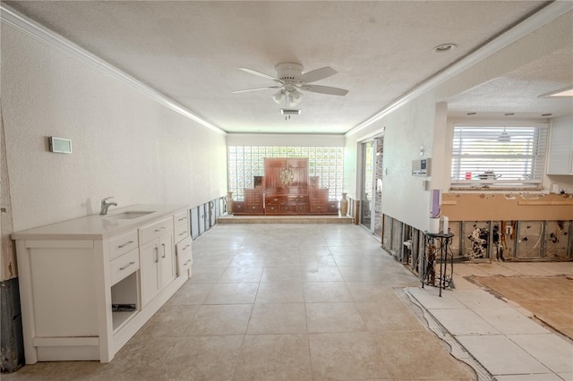 hallway featuring a textured ceiling, crown molding, and sink