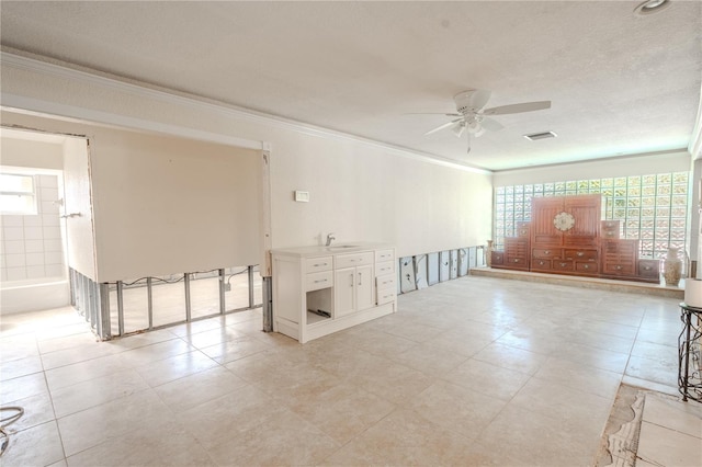 unfurnished room featuring crown molding, sink, ceiling fan, and a textured ceiling