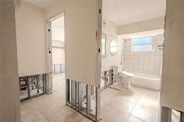 bathroom featuring tiled shower / bath combo and toilet