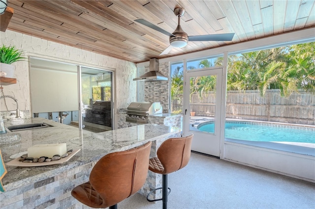 sunroom / solarium featuring ceiling fan, sink, and wood ceiling