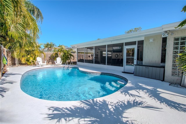 view of swimming pool with a patio and a sunroom