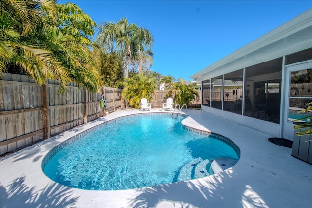 view of swimming pool with a sunroom and a patio