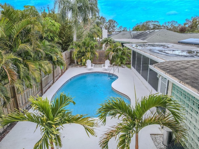 view of swimming pool with a sunroom and a patio