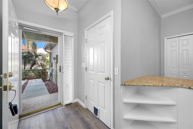 entryway with dark wood-type flooring and ornamental molding