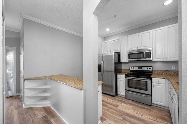 kitchen featuring appliances with stainless steel finishes, white cabinets, and ornamental molding