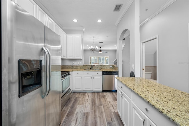 kitchen featuring sink, stainless steel appliances, white cabinetry, and ceiling fan with notable chandelier