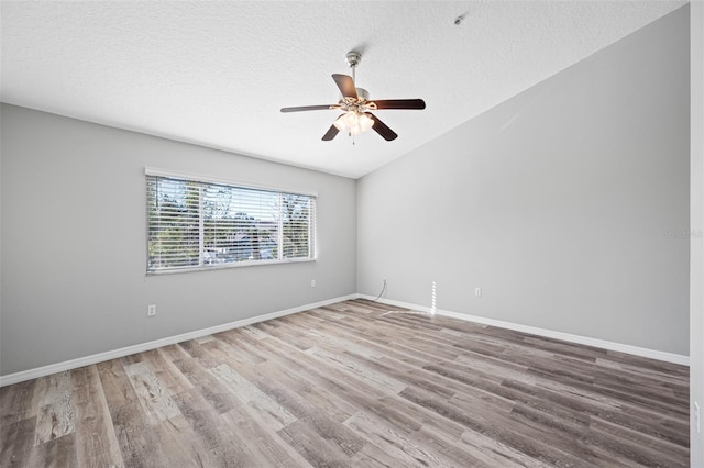 spare room with lofted ceiling, a textured ceiling, ceiling fan, and hardwood / wood-style flooring