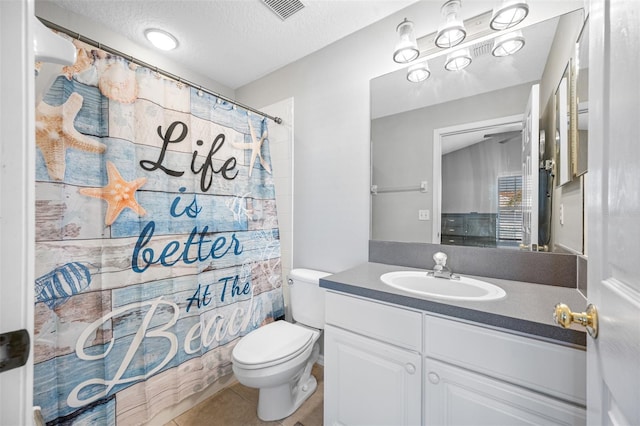 bathroom with curtained shower, a textured ceiling, tile patterned flooring, toilet, and vanity