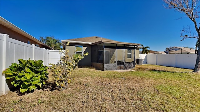 rear view of property with a lawn, cooling unit, and a sunroom