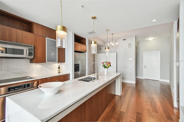 kitchen featuring decorative backsplash, sink, pendant lighting, and appliances with stainless steel finishes