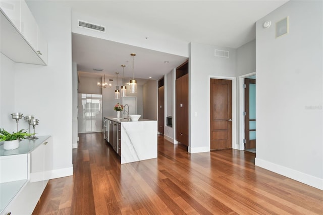 kitchen with white cabinets, a kitchen island with sink, sink, pendant lighting, and dishwasher