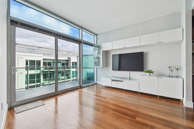 unfurnished living room featuring hardwood / wood-style flooring and expansive windows