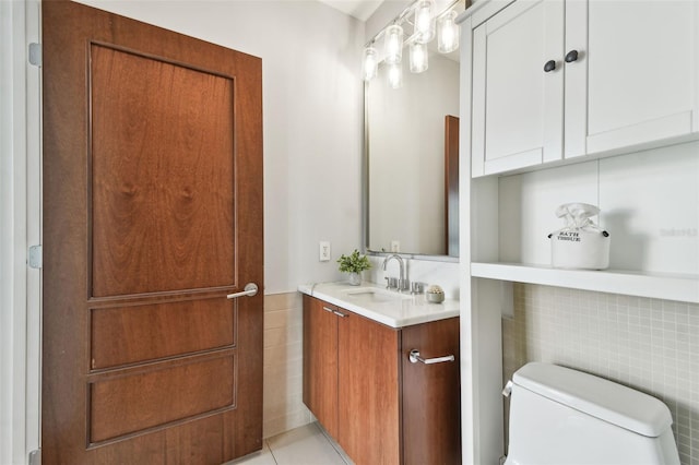 bathroom featuring tile patterned flooring, vanity, toilet, and tile walls