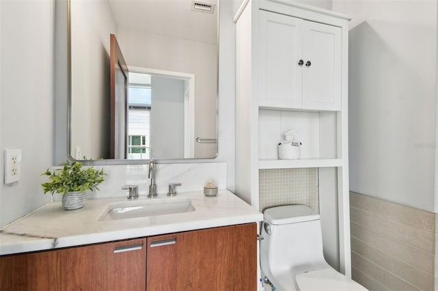 bathroom featuring vanity and toilet