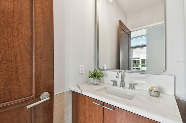 bathroom with vanity and tile walls