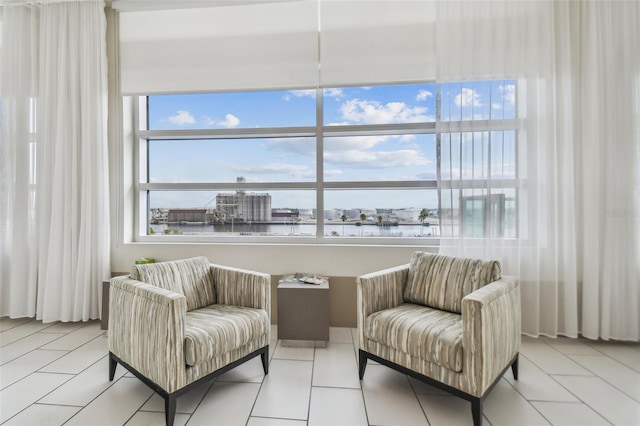 living area featuring a water view and light tile patterned floors