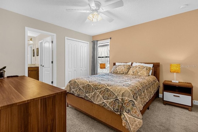 carpeted bedroom with a closet, ceiling fan, and ensuite bathroom