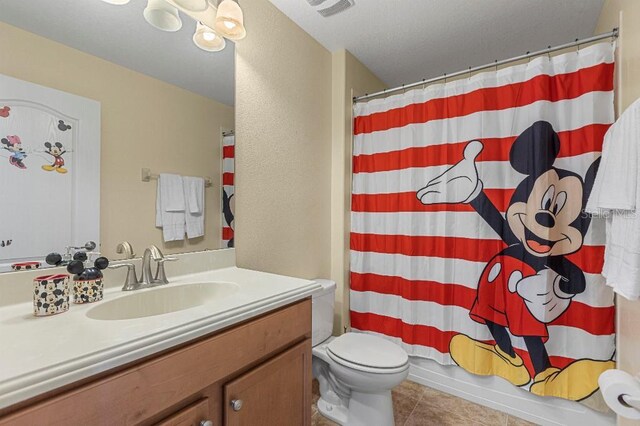 full bathroom with tile patterned floors, vanity, toilet, and shower / bath combo