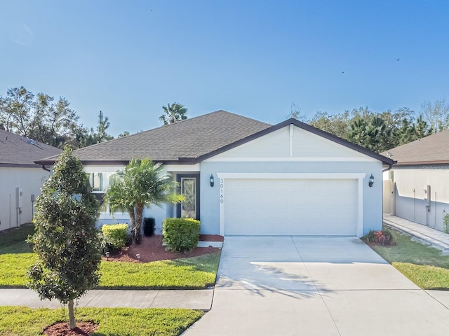 ranch-style house featuring concrete driveway, a shingled roof, an attached garage, and stucco siding