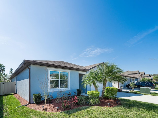 view of front of property with stucco siding, an attached garage, a front yard, fence, and driveway