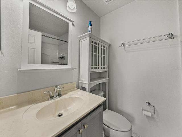 bathroom with vanity, toilet, and walk in shower