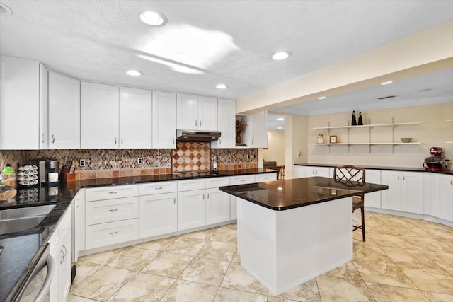 kitchen with dishwasher, backsplash, dark stone counters, black electric stovetop, and white cabinetry