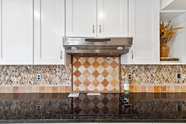 kitchen with backsplash, black electric cooktop, white cabinets, and ventilation hood