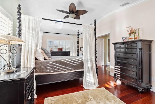 bedroom featuring ceiling fan, crown molding, dark wood-type flooring, and a textured ceiling