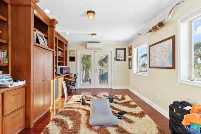 office area featuring french doors, dark hardwood / wood-style flooring, ornamental molding, a textured ceiling, and an AC wall unit