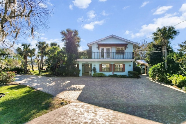 view of front of property with a balcony, covered porch, and a front yard