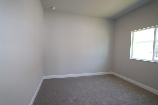 unfurnished room featuring dark colored carpet