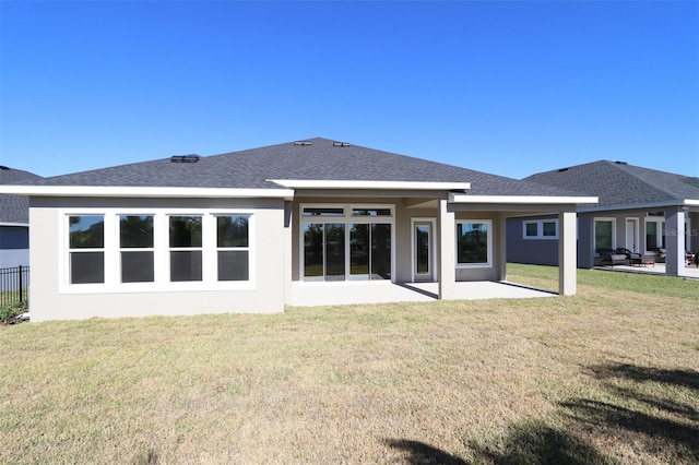 back of house featuring a lawn and a patio