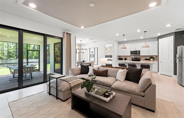 living room with light tile patterned floors, an inviting chandelier, and sink