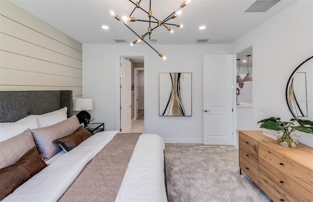 carpeted bedroom featuring a chandelier and ensuite bath