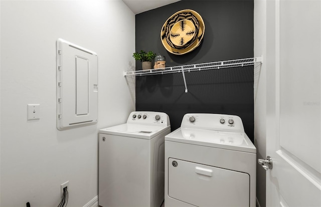 clothes washing area with electric panel and washer and dryer