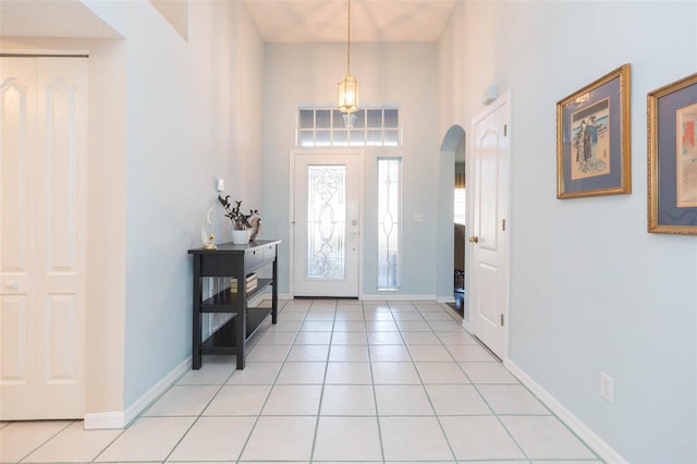 tiled foyer entrance with a towering ceiling