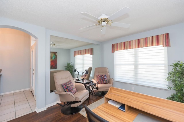 sitting room with hardwood / wood-style flooring, ceiling fan, and a textured ceiling