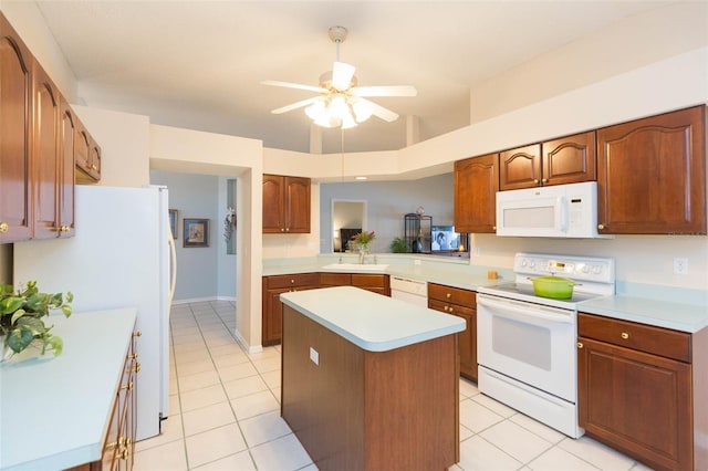 kitchen with ceiling fan, white appliances, a kitchen island, and light tile patterned floors