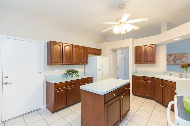 kitchen featuring sink, a center island, ceiling fan, white refrigerator with ice dispenser, and stove