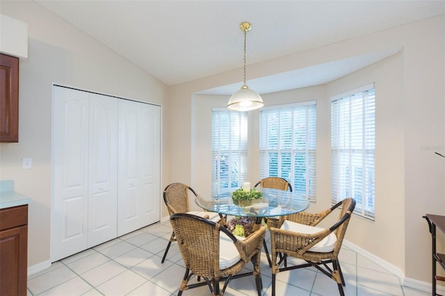 dining space featuring a wealth of natural light, light tile patterned flooring, and vaulted ceiling