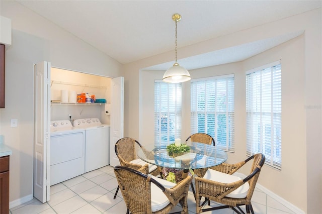 dining area featuring light tile patterned floors, vaulted ceiling, and independent washer and dryer