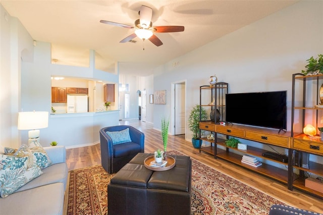 living room with ceiling fan and light hardwood / wood-style flooring