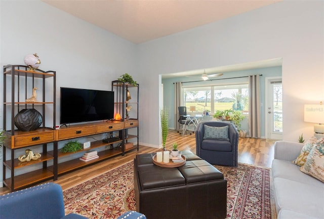 living room featuring wood-type flooring and ceiling fan