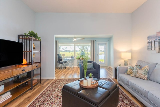 living room featuring wood-type flooring and ceiling fan