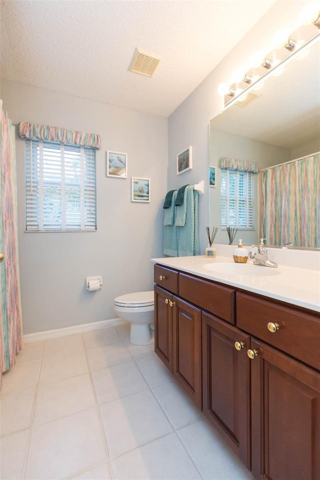 bathroom featuring vanity, tile patterned floors, a textured ceiling, and toilet