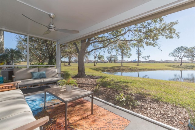 sunroom featuring ceiling fan and a water view